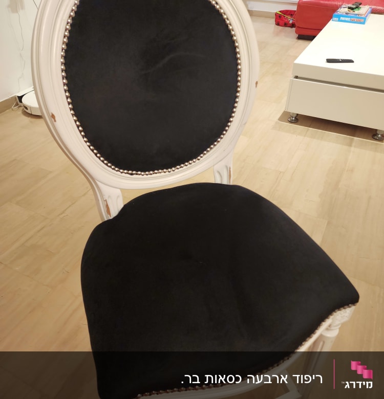 כיסא מרופד בבד שחור עם מסגרת לבנה